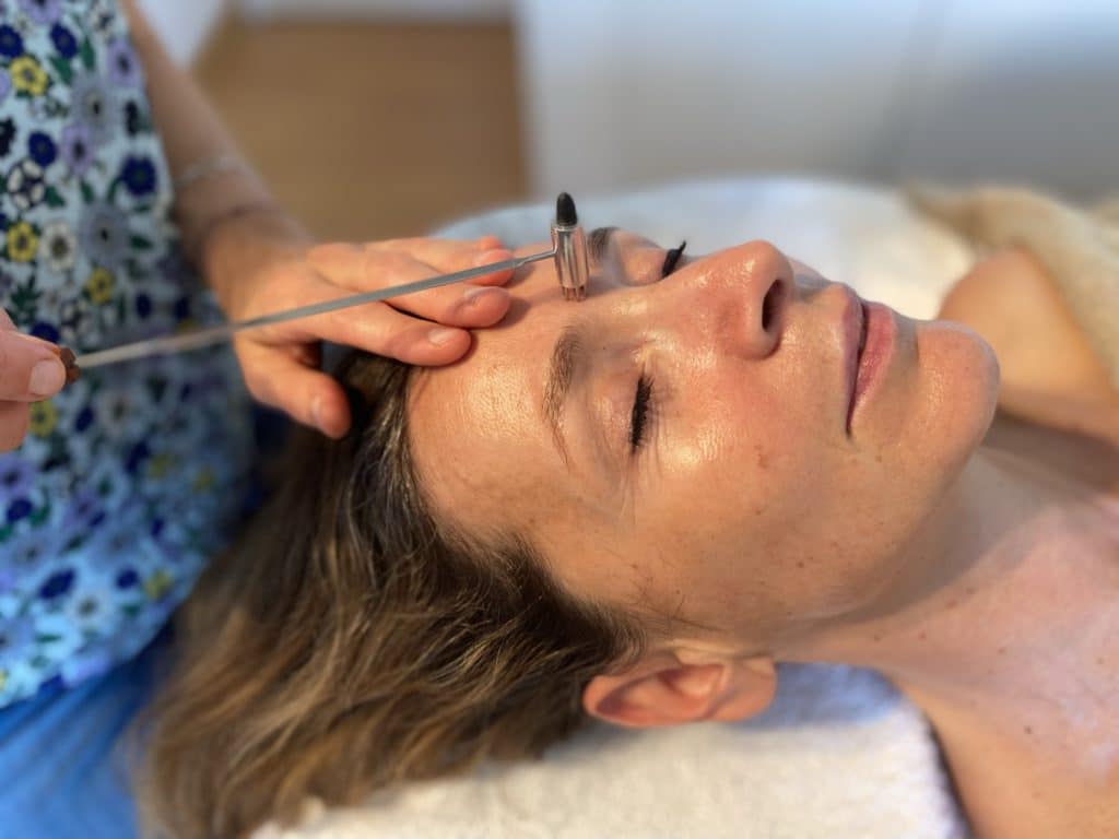 Réflexologue pratiquant une séance de réflexologie faciale Dien Chan