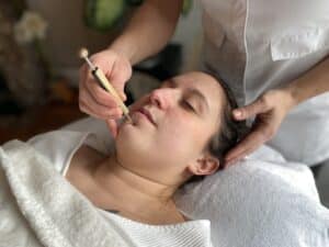 Réflexologue pratiquant une séance de réflexologie faciale Dien Chan