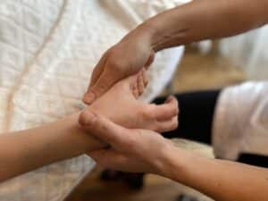 Réflexologue pratiquant une séance de réflexologie palmaire